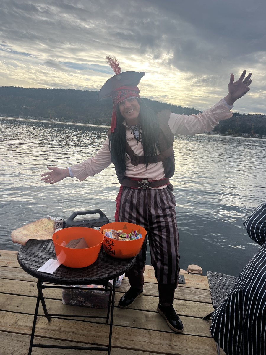 Captain Colin in pirate costume on a Lake Sammamish dock with treat bowls and a treasure map