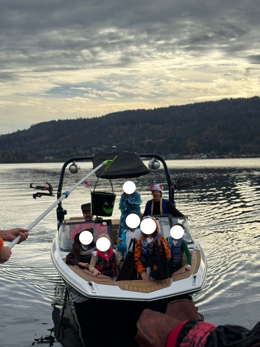 Children in costume aboard a boat reaching for treats during Dock or Treat